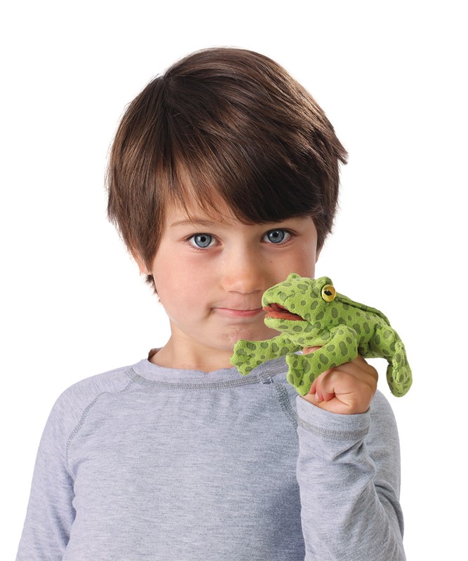 Boy holding a green spotted Folkmanis mini frog finger puppet on his index finger, with a yellow eye and movable mouth