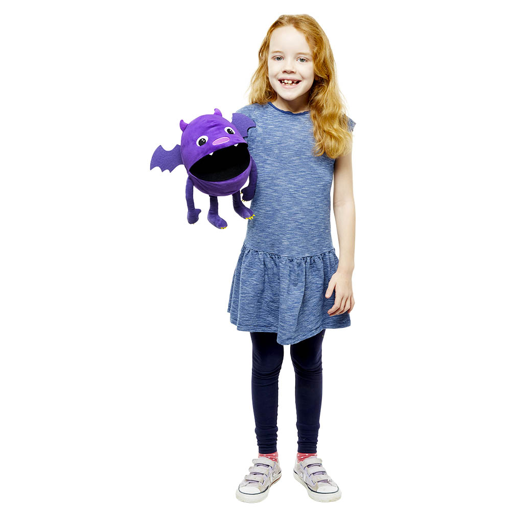 Girl holding up the The Puppet Company purple baby monster hand puppet, usage example from the side