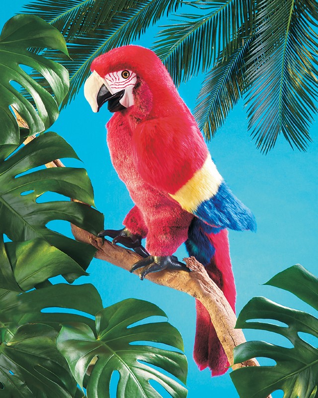 Folkmanis Handpuppe Ara in leuchtendem Rot mit gelb-blauen Flügeln, auf einem Ast sitzend, vor türkisblauem Hintergrund mit Monstera-Blättern