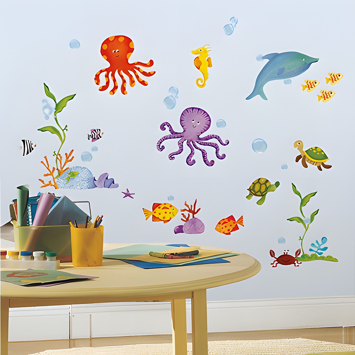 RoomMates Wandsticker Adventures Under the Sea, bunte Meerestier-Motive (Oktopus, Delfin, Fische, Schildkröten) an einer hellen Zimmerwand über einem Kindertisch