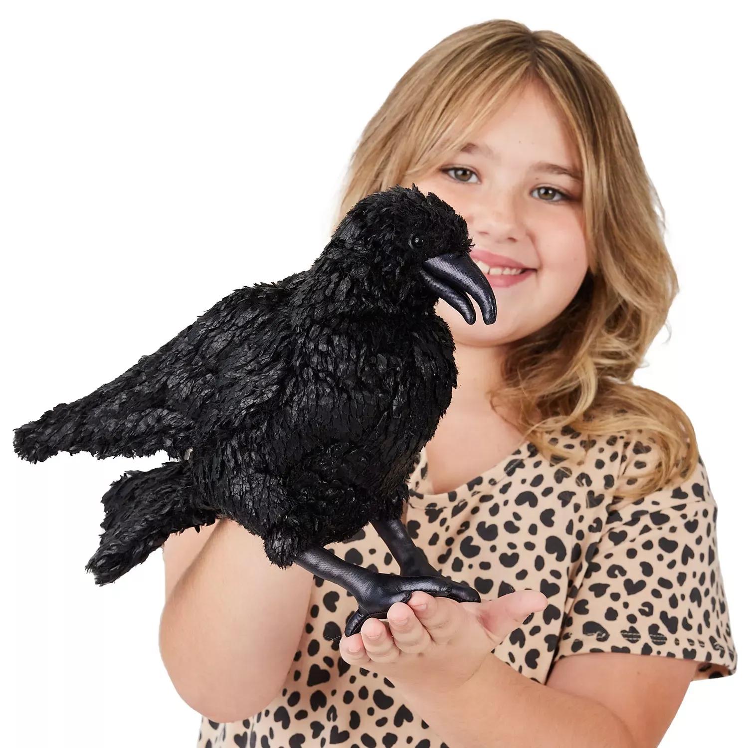 Folkmanis Handpuppe Krähe in tiefem Schwarz mit detailliertem Gefieder, gebogenem Schnabel und Krallen, von Mädchen auf der Hand gehalten