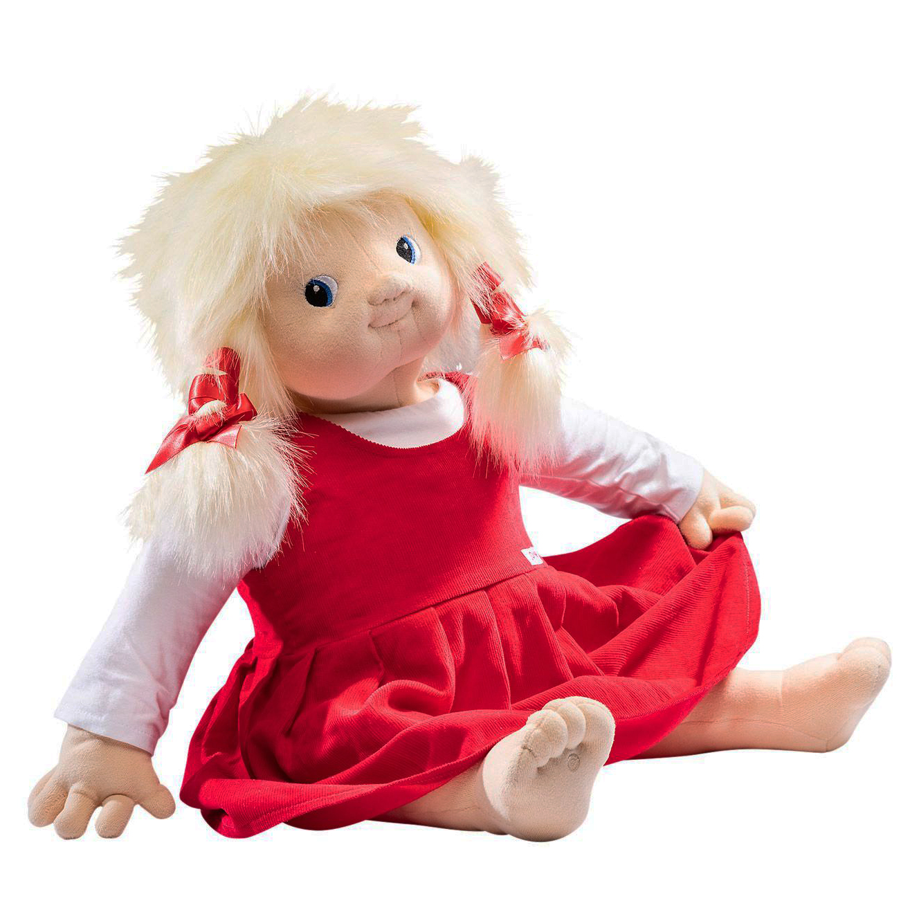 Joyk Empathiepuppe Nelly mit blonden Zöpfen, weißem Shirt und rotem Latzkleid, sitzend
