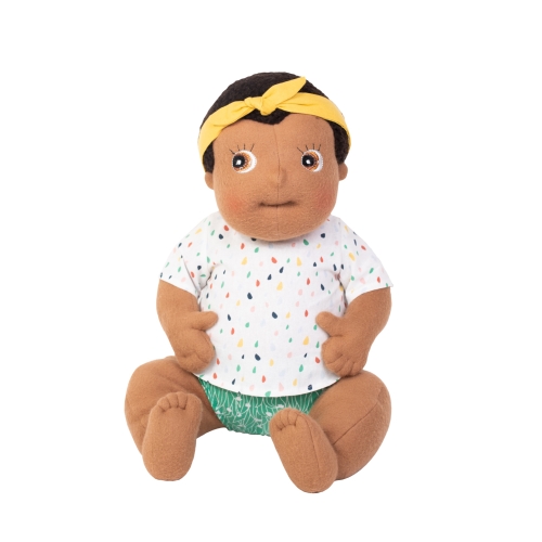 Rubens Barn Baby-Puppe Flo mit gelbem Haarband, getupftem Shirt und grüner Windelhose, sitzend