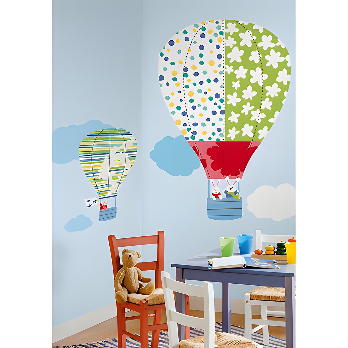 RoomMates wall decal Hot Air Balloons, colourful patterned hot air balloons with clouds on a light blue children's room wall above a table