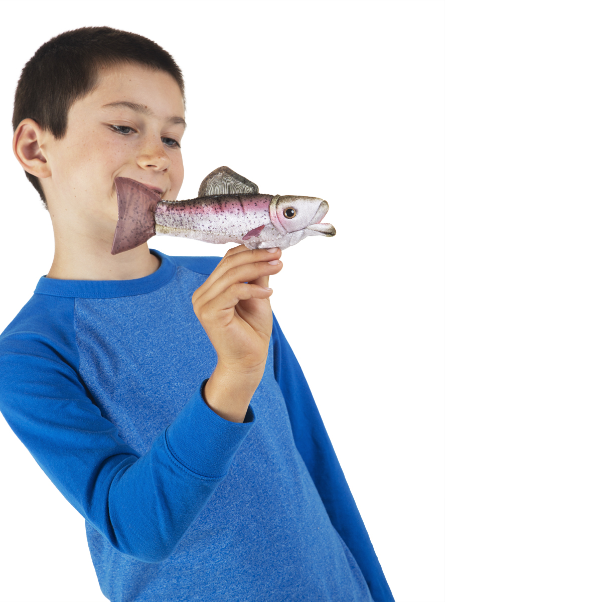 Boy holding a Folkmanis mini rainbow trout finger puppet whose mouth touches his lips, realistic pink and silver colouring