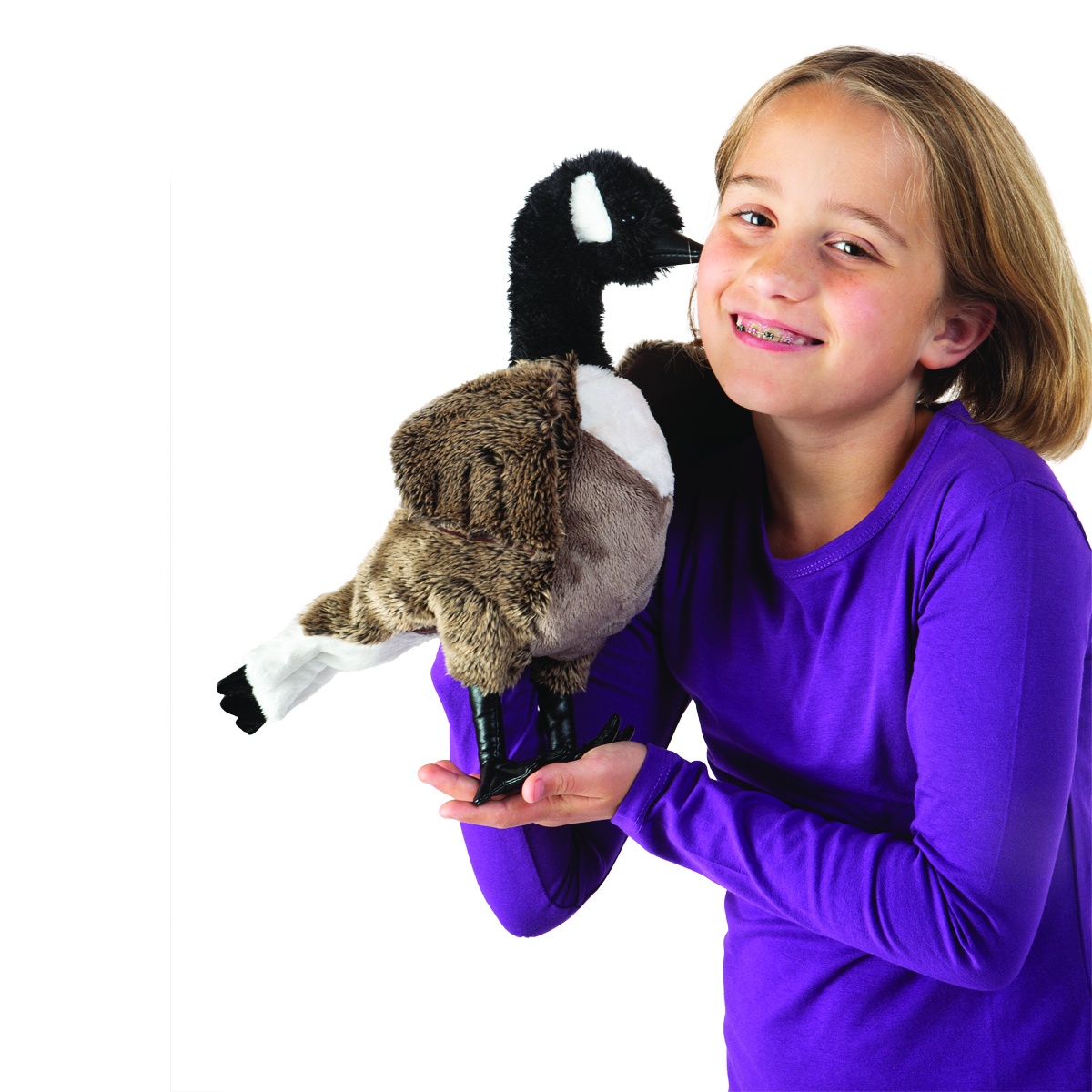 Mädchen hält Folkmanis Handpuppe Kanada-Gans mit schwarzem Kopf, weißem Wangenfleck und braunem Gefieder in die Höhe.