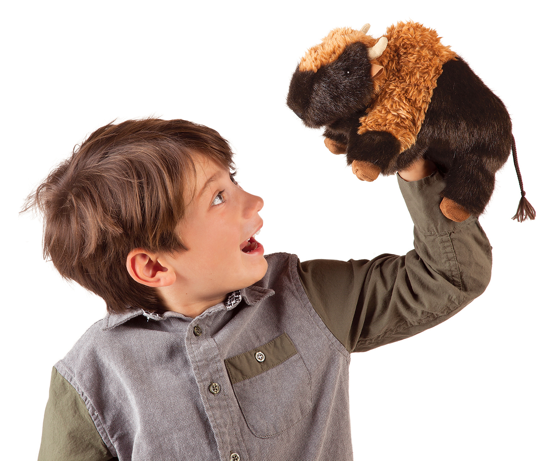 Boy holding a Folkmanis bison hand puppet with dark brown fur and light-coloured horns up in the air while looking at it