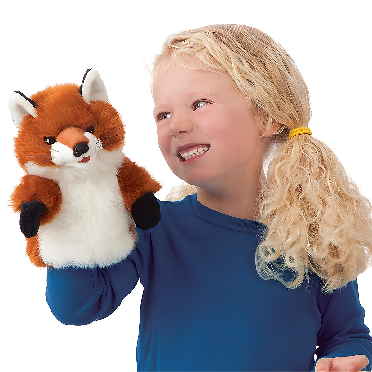 Mädchen hält Folkmanis Handpuppe Kleiner Fuchs mit rotbraunem Fell und weißem Bauch lächelnd in die Höhe