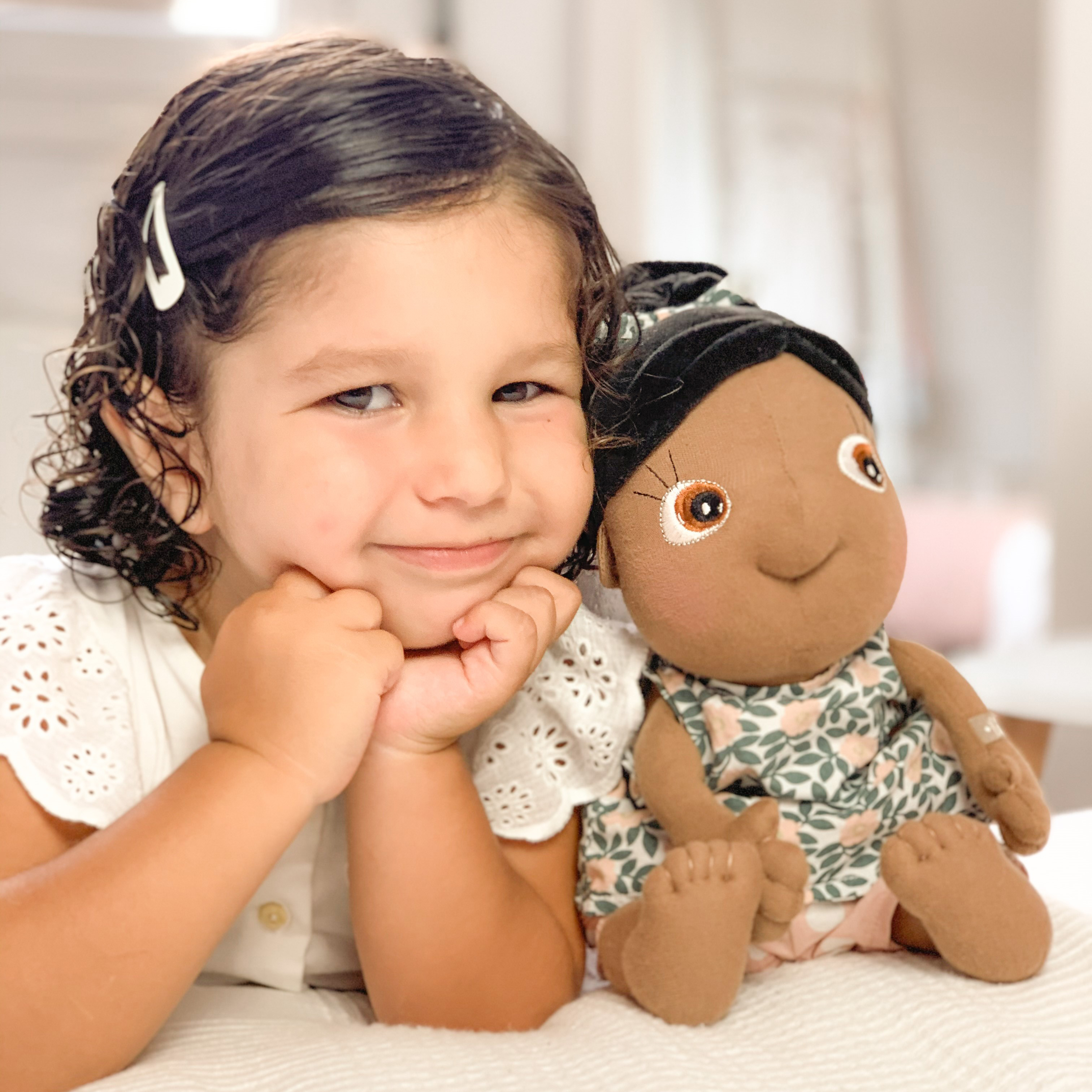 Child snuggling up to the Rubens Tummies doll Summer