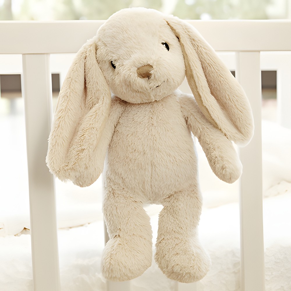 Cloud b sleep aid Bubbly Bunny, lifestyle photo of beige bunny plush hanging on crib rail