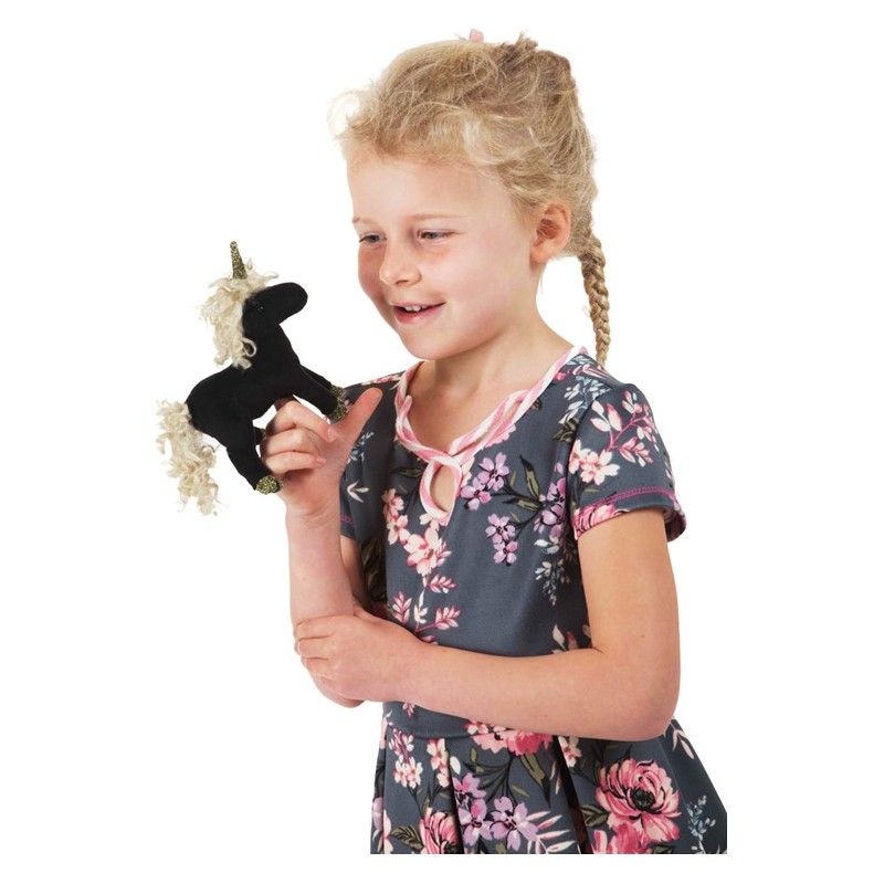 Mädchen hält Folkmanis Fingerpuppe mini schwarzes Einhorn mit goldenem Horn und lockiger Mähne auf dem Finger.