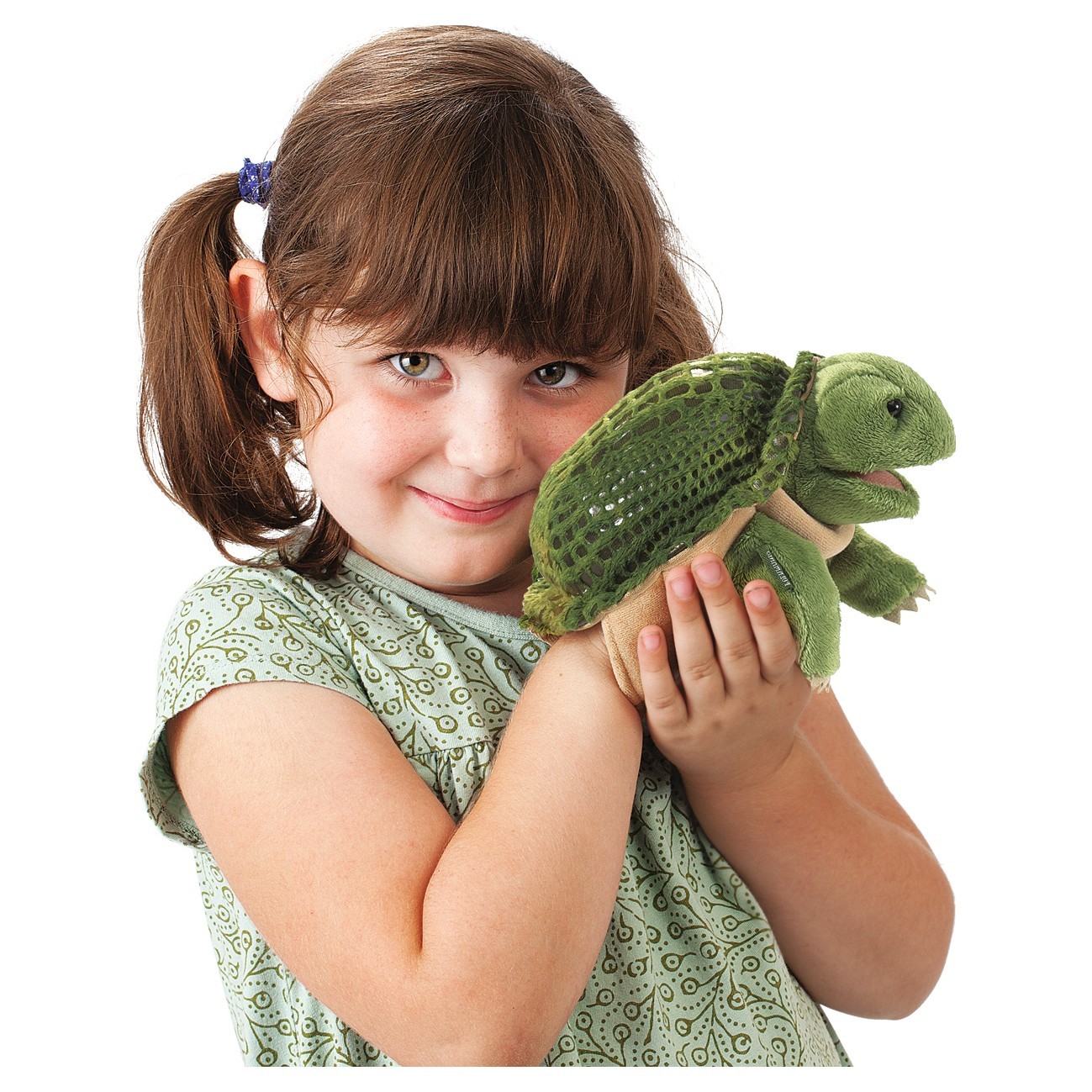Mädchen hält Folkmanis Handpuppe kleine Schildkröte mit grünem Panzer und Plüschkopf in beiden Händen