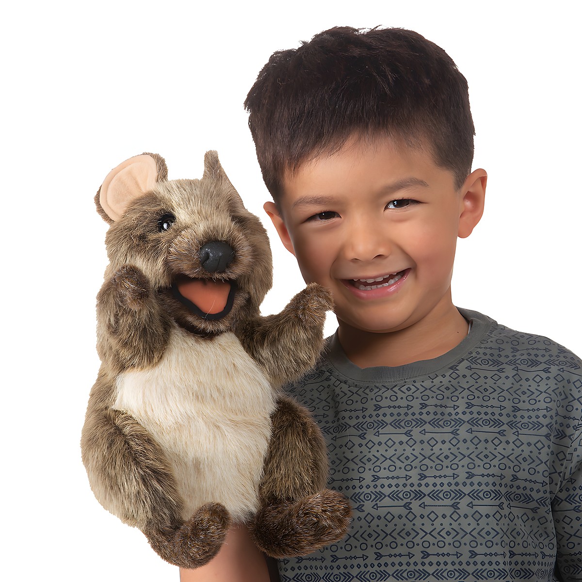 Lachender Junge hält Folkmanis Handpuppe Kurzschwanzkänguru mit geöffnetem Maul und braunem Plüschfell in die Höhe.