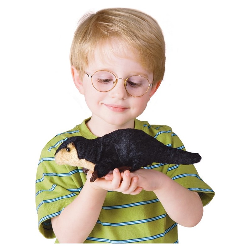 Junge mit Brille hält die Folkmanis Fingerpuppe mini Flussotter in der offenen Hand und schaut lächelnd darauf.