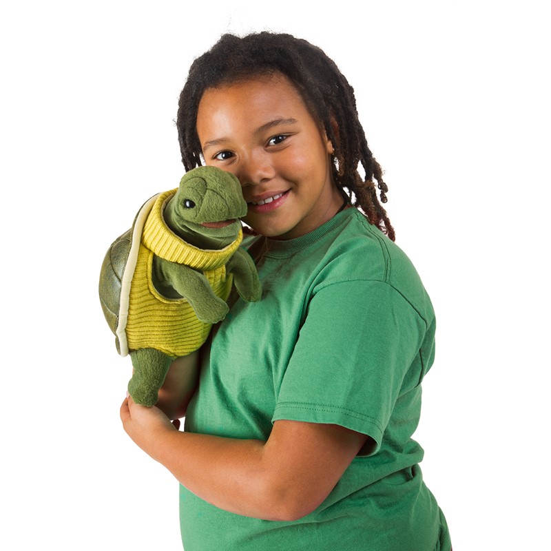Folkmanis Handpuppe Schildkröte mit gelbem Rollkragenpullover, von lächelndem Kind gehalten, Seitenansicht