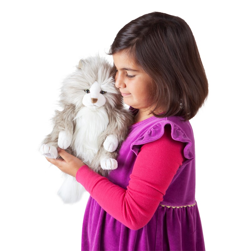 Mädchen hält die Folkmanis Handpuppe pummelige Katze mit grau-weißem Langfell seitlich ans Gesicht geschmiegt.