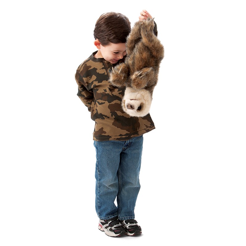 Boy holding a Folkmanis baby sloth hand puppet with brown fur and a light-coloured face upside down in his arms