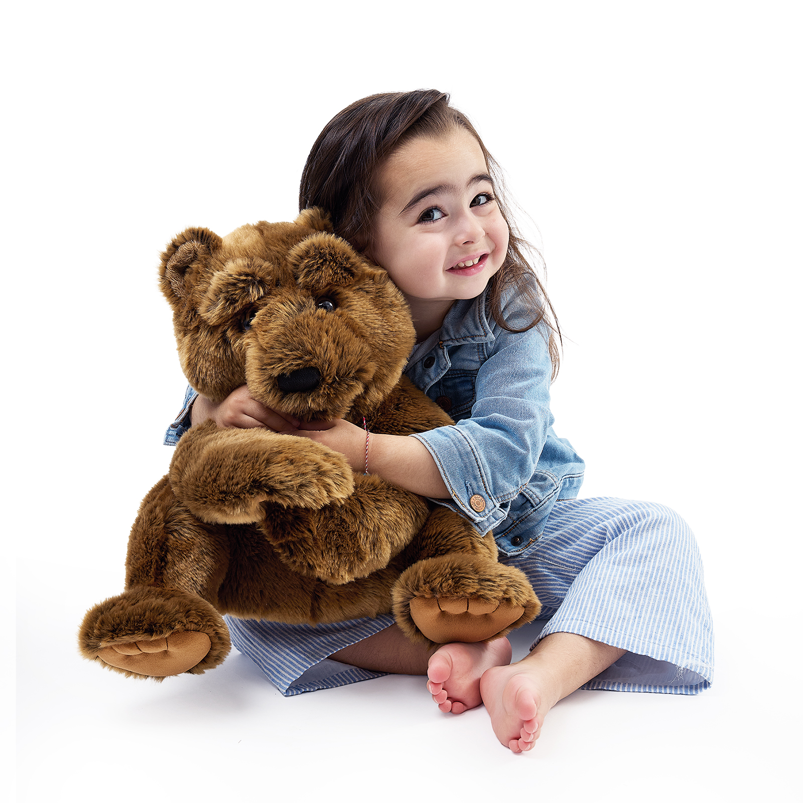 Folkmanis Handpuppe großer Bär wird von einem Mädchen umarmt, beide Vorderpfoten sichtbar, das Maul geschlossen.