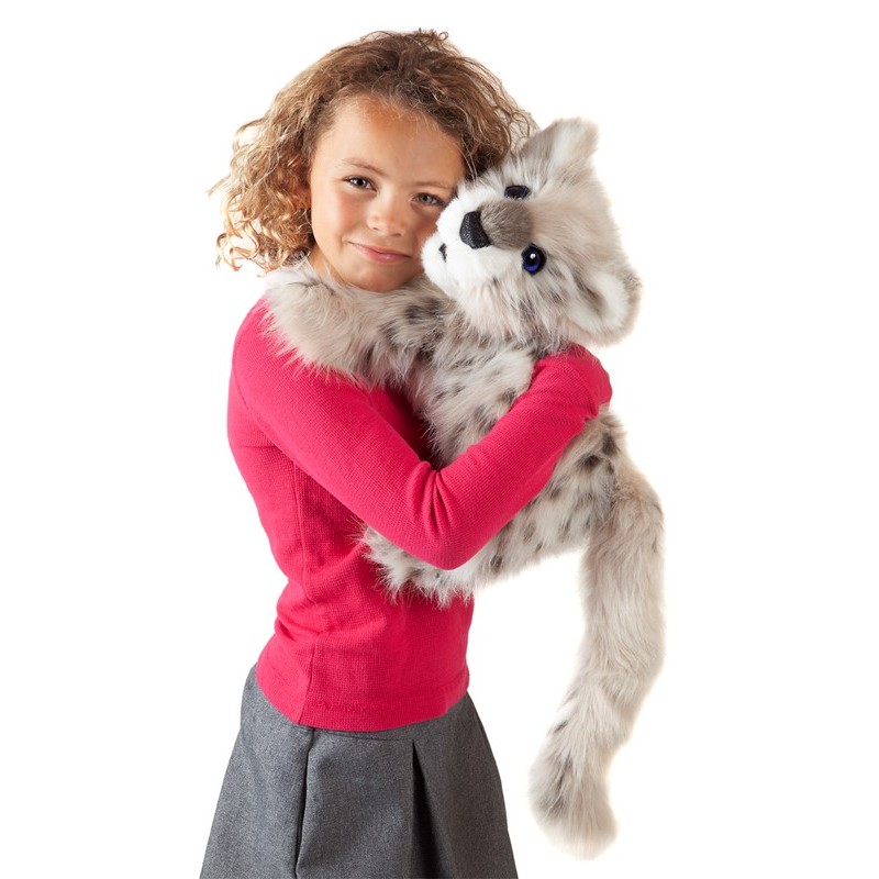 Mädchen hält Folkmanis Handpuppe Baby Schneeleopard mit grau-weißem Fell und dunklen Flecken im Arm.