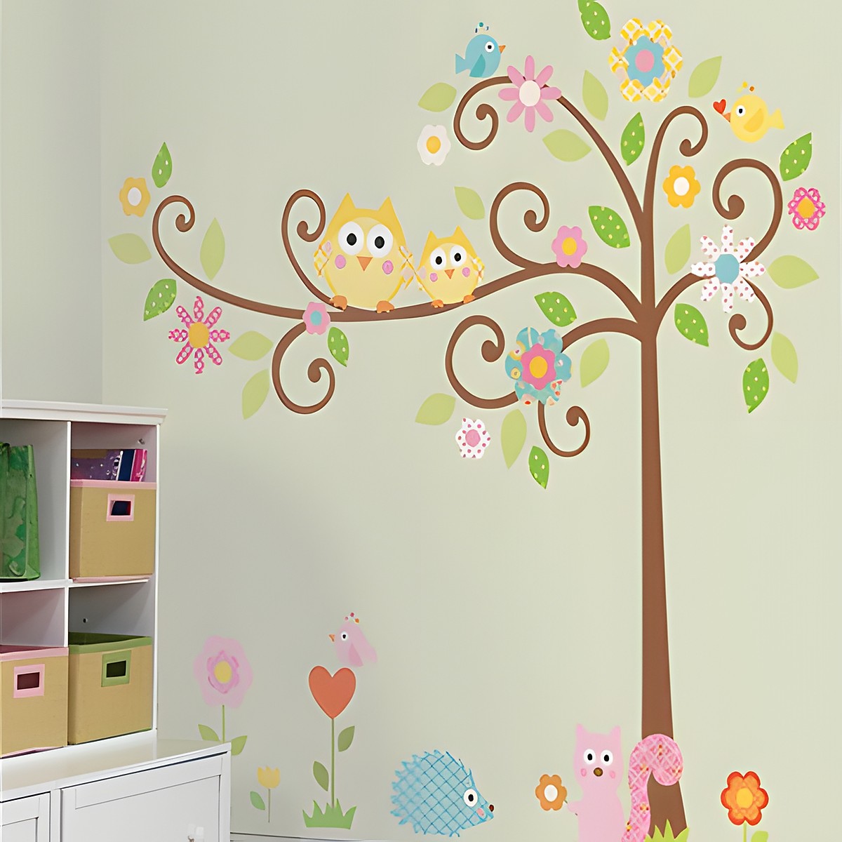 RoomMates wall decal Scroll Tree, curved tree with owls, blossoms and leaves above hedgehog and squirrel motifs on a green children's room wall