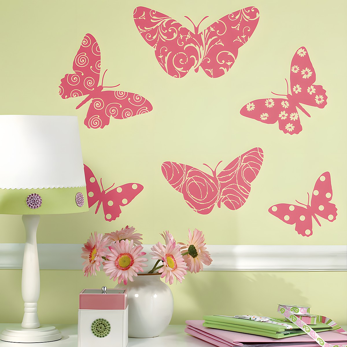 RoomMates wall decal Flocked Butterfly, pink patterned butterfly motifs on a light green wall above a chest of drawers