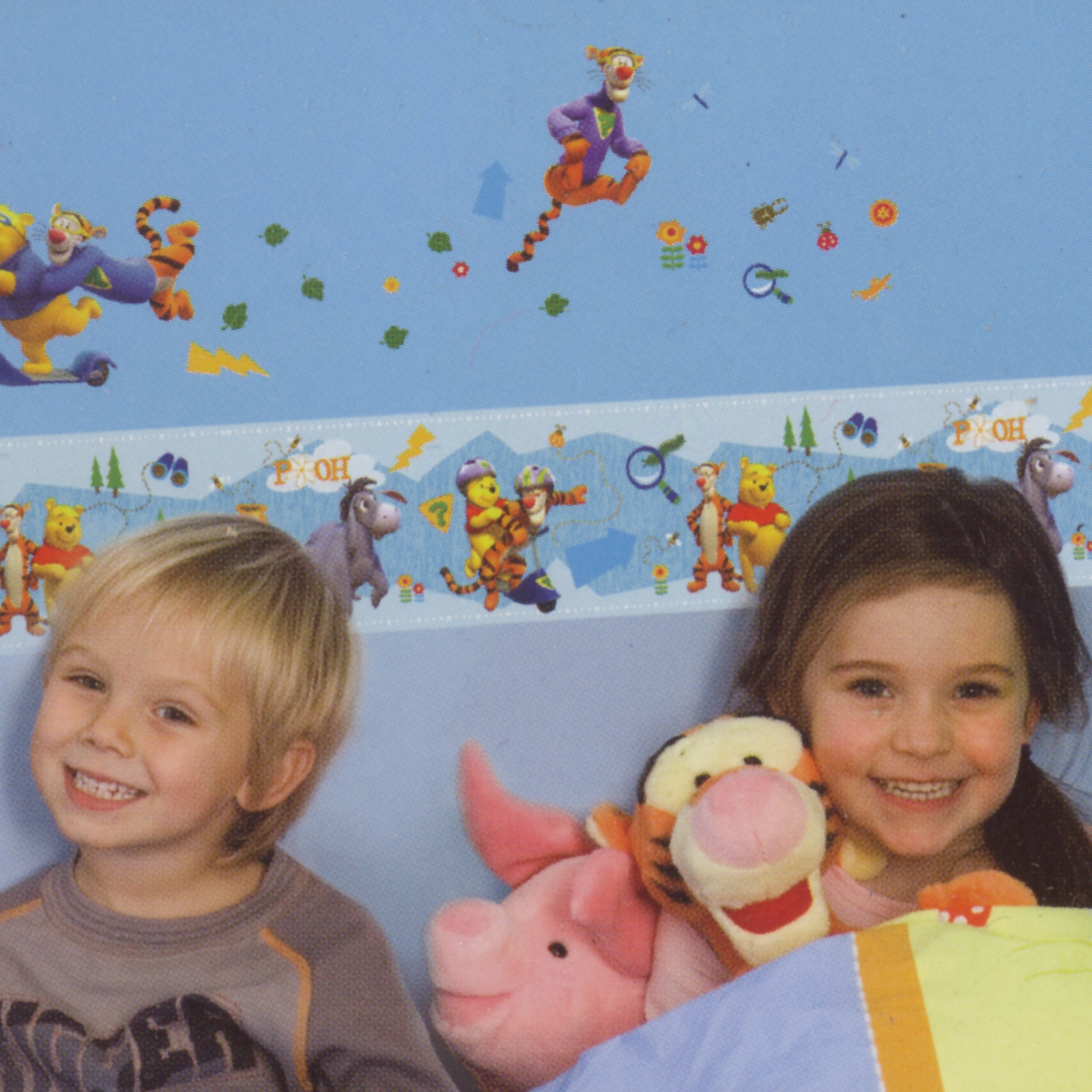 decofun border My Friends Tigger & Pooh above a bed, two smiling children holding Tigger and Piglet plush toys