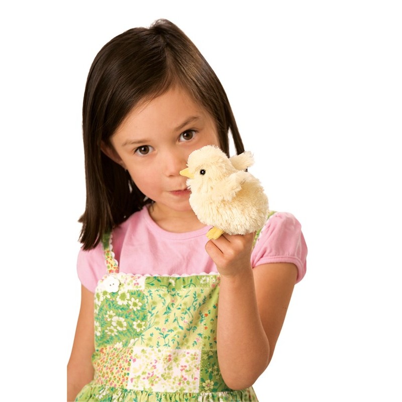 Mädchen hält Folkmanis Fingerpuppe mini Küken in cremeweiß mit gelbem Schnabel nah ans Gesicht