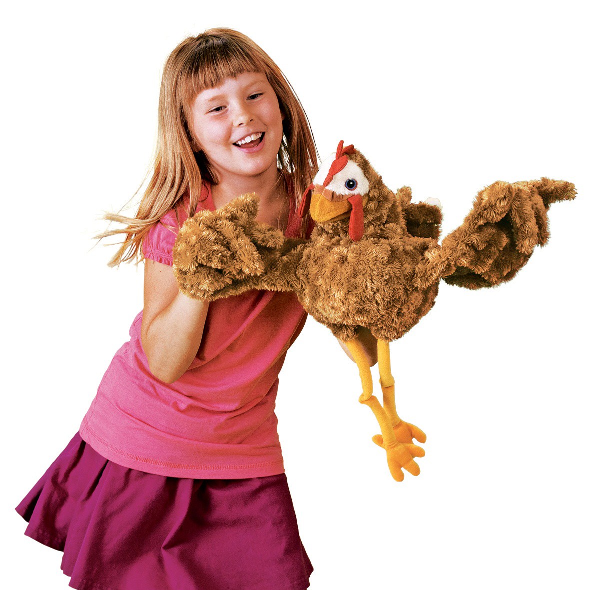 Smiling girl playing with the Folkmanis chicken hand puppet in brown plush with a red comb and yellow legs, full-body view