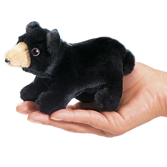 Folkmanis Mini-Fingerpuppe Schwarzbär in schwarzem Plüsch mit beigem Maul, liegend auf einer Handfläche