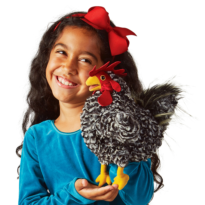 Girl holding a Folkmanis rooster hand puppet with black-and-white curly feathers, a red comb, and yellow legs