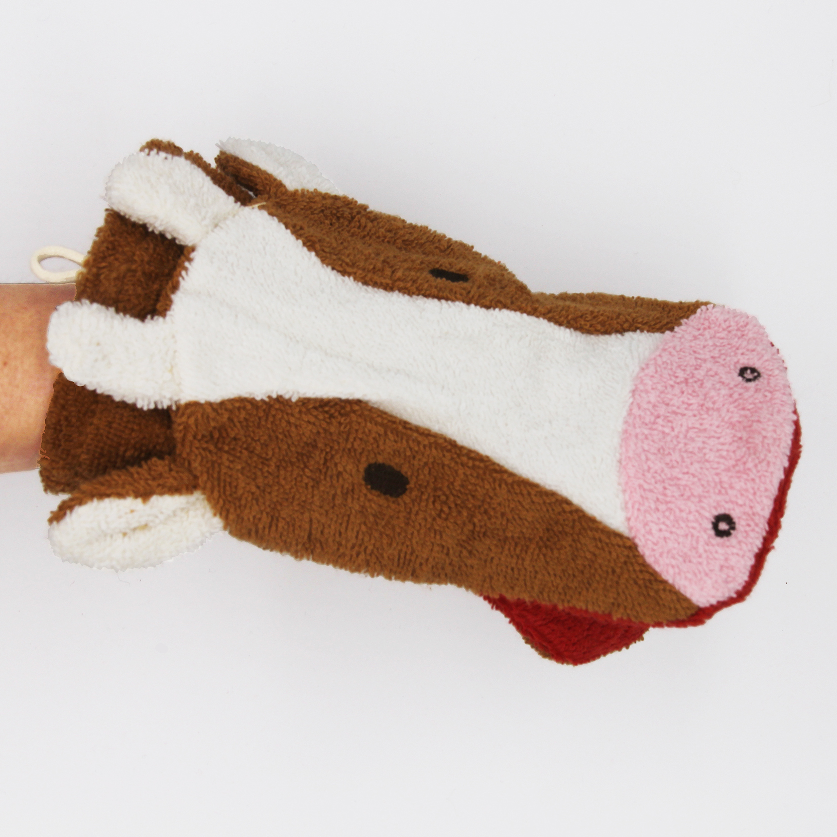 Fürnis organic washcloth cow Klara worn as mitt on arm, pink snout with red mouth lining visible