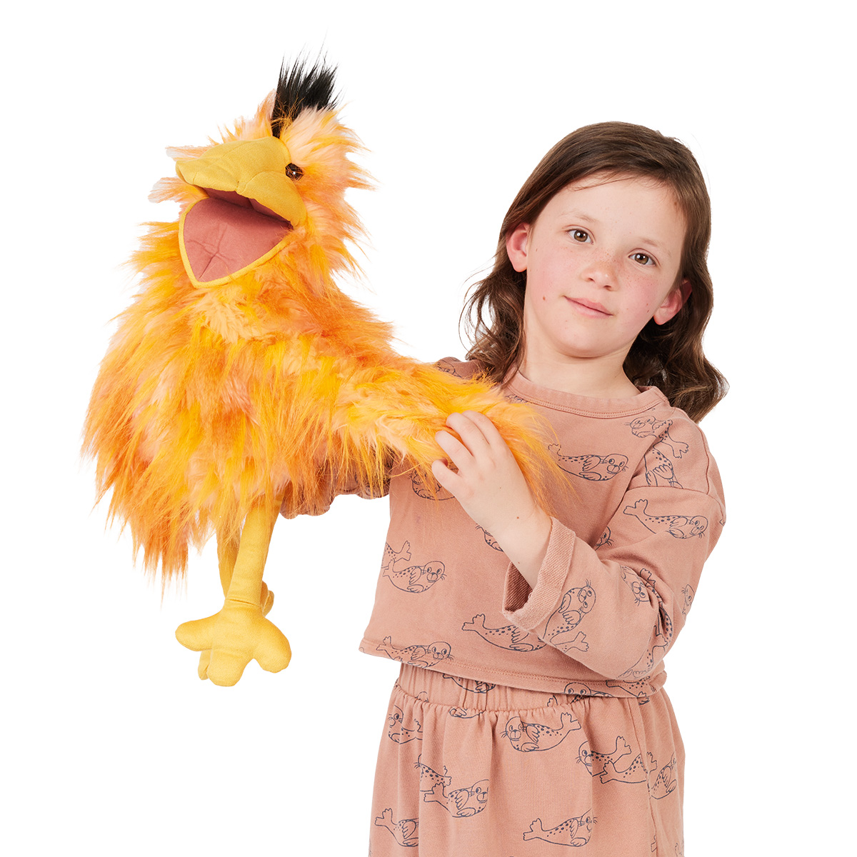 Girl holding a Folkmanis Silly Bird hand puppet with orange-yellow plush feathers, a black crest and a movable beak towards the camera