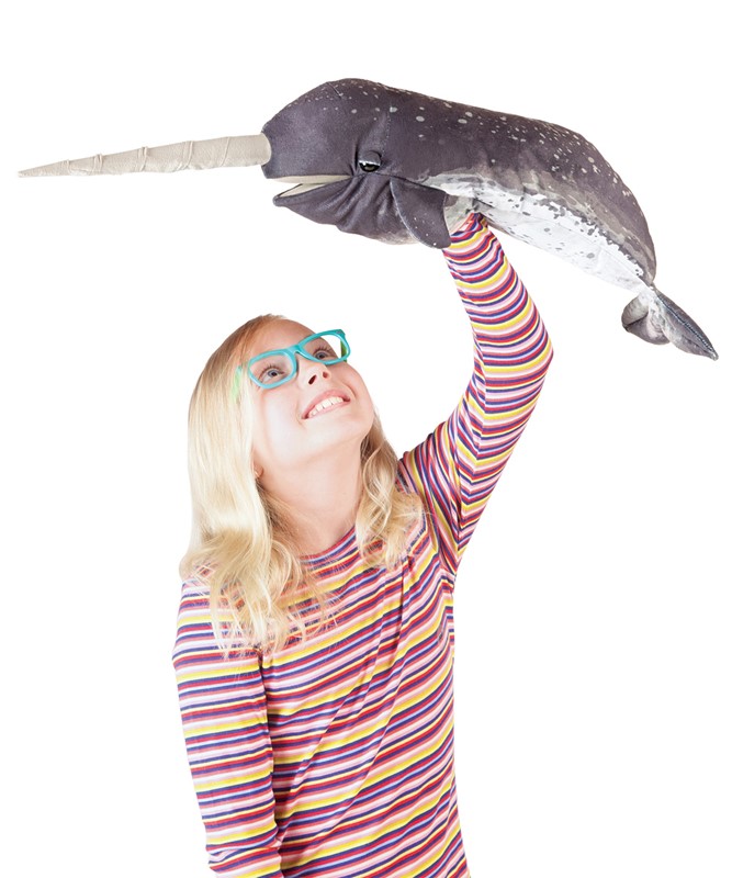 Mädchen hält Folkmanis Narwal-Handpuppe mit realistischem Fell-Print und langem Horn hoch über den Kopf