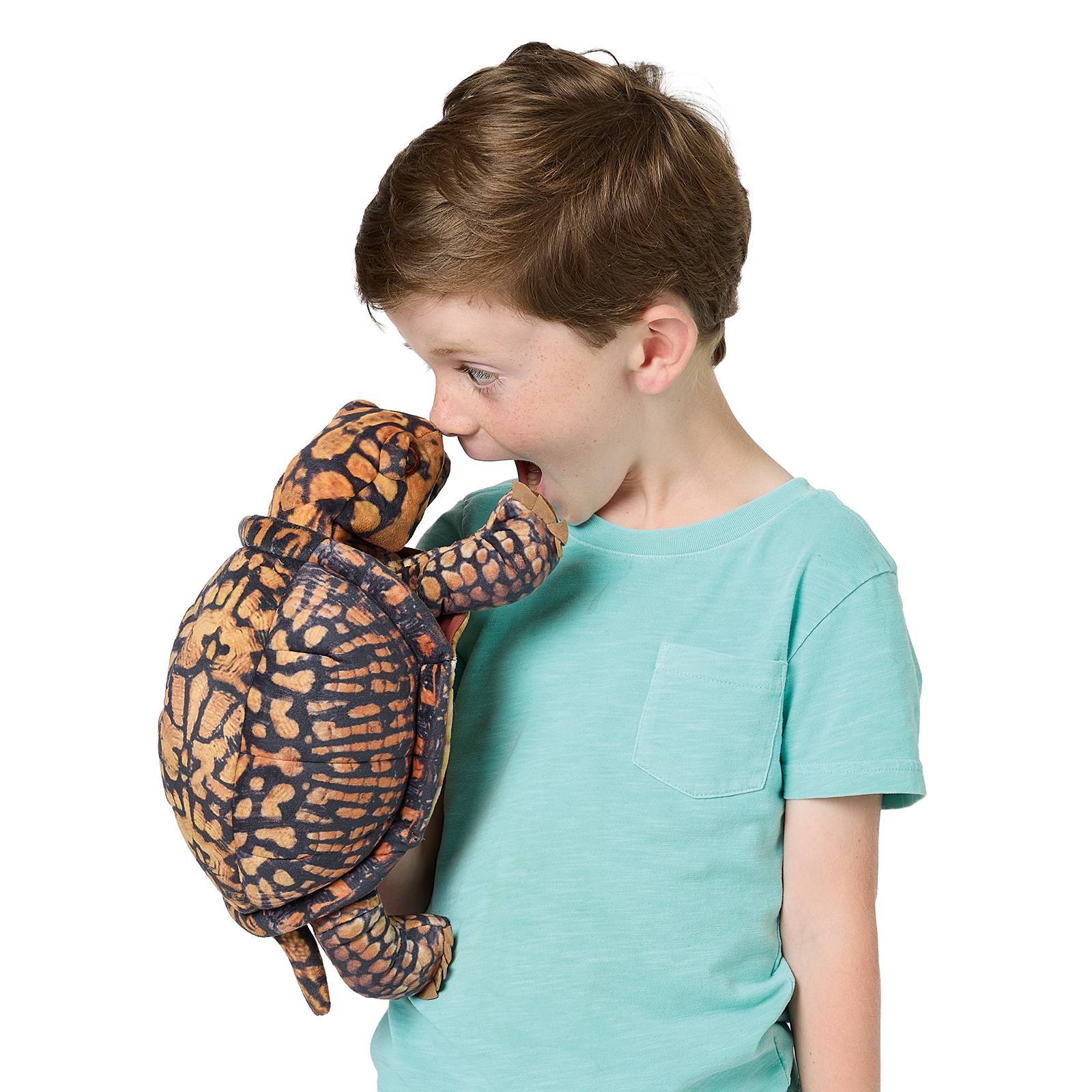 Boy holding a Folkmanis box turtle hand puppet with a detailed orange and black printed shell up to his face