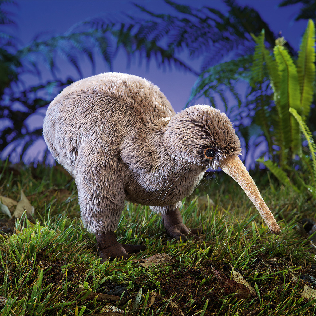 Folkmanis Handpuppe Kiwi mit braunem Plüschgefieder und langem Schnabel, in Seitenansicht auf Grasboden vor blauem Hintergrund