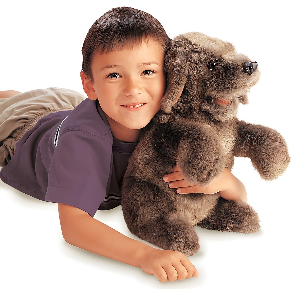 Junge umarmt die graubraune Folkmanis Handpuppe sitzender Hund mit weichem Fell und schwarzer Nase