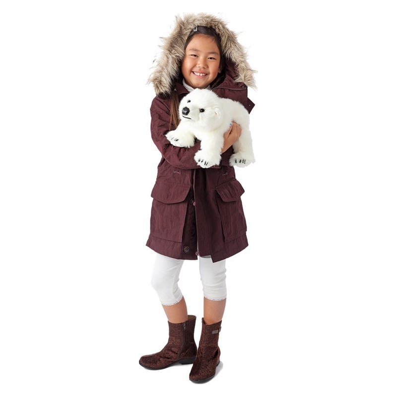 Girl holding a white Folkmanis polar bear cub hand puppet in her arms and smiling at the camera