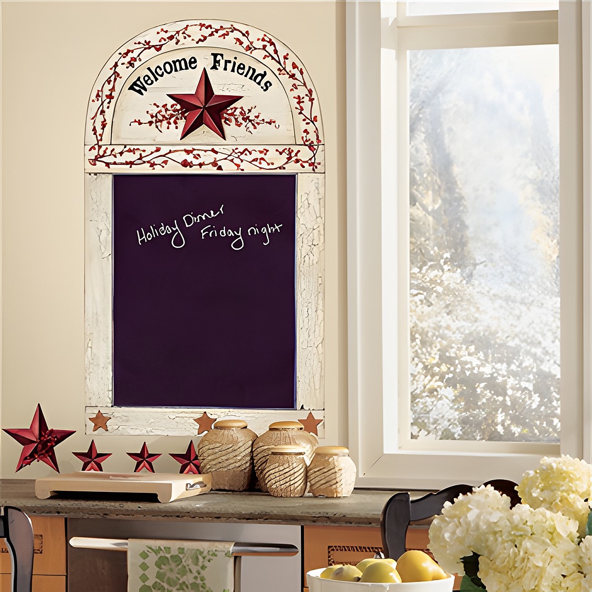 RoomMates writable chalkboard Country Chalkboard, cream-coloured frame with "Welcome Friends" lettering, a red star and berry vine above a writable chalkboard surface, on a kitchen wall