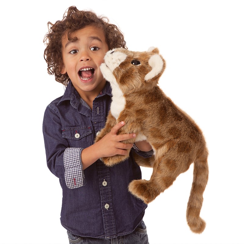 Kind hält Folkmanis Handpuppe Löwenbaby aus braunem Plüsch mit hellem Maul nah ans Gesicht.