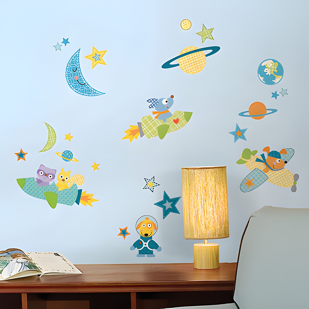 RoomMates wall decal Rocketdog, animals in rockets and spaceships among stars, moons and planets on a light blue children's room wall above a chest of drawers
