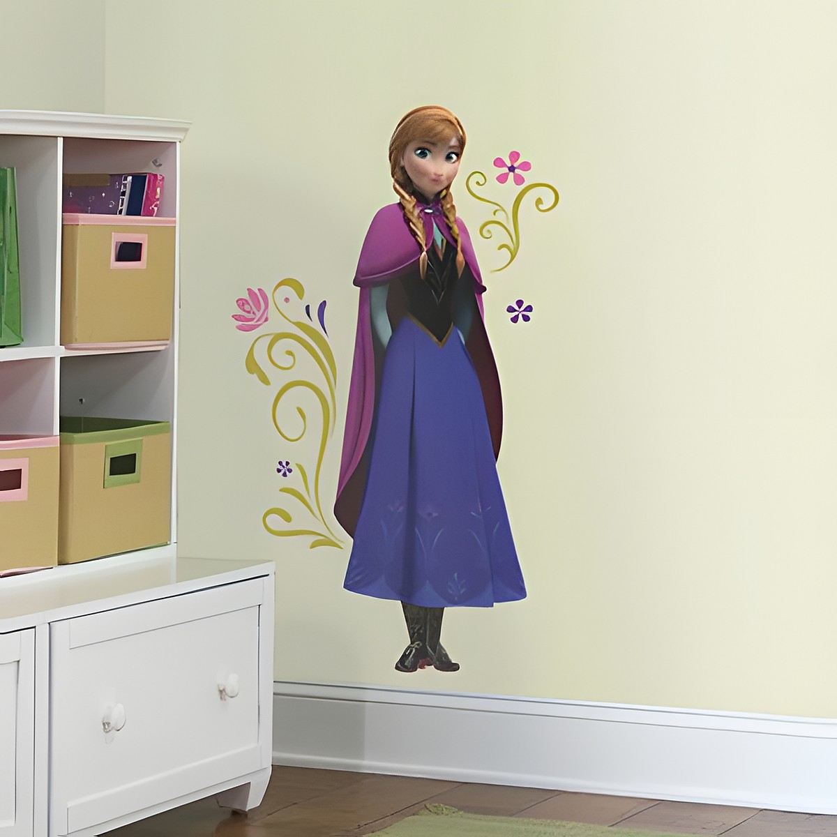 RoomMates wall decal Disney Frozen Anna with Cape, Anna in a blue dress and pink cape with floral vine motifs, on a yellow children's room wall