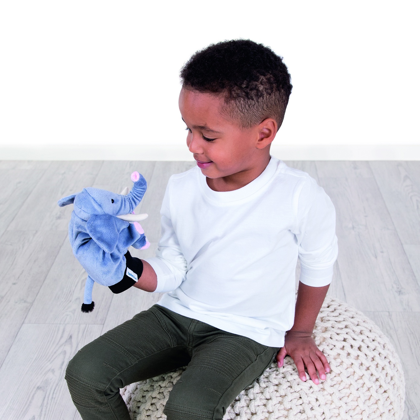 Boy looking at the Beleduc hand puppet elephant on his hand, usage example