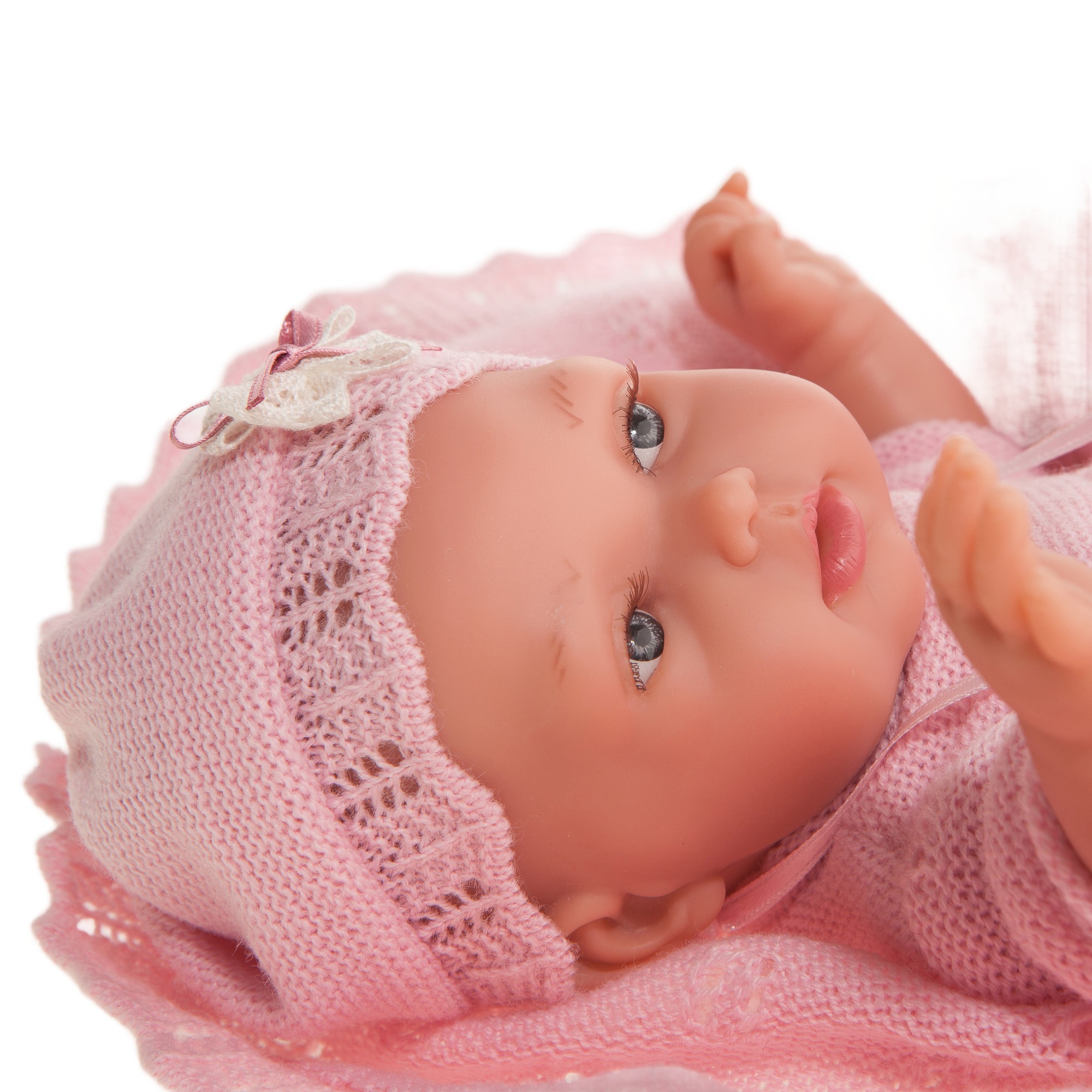 Antonio Juan Babypuppe Peke, Nahaufnahme des liegenden Gesichts mit rosa Mütze, Hand nah am Mund