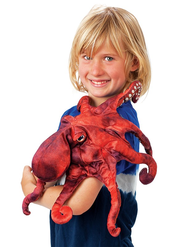 Child holding the Folkmanis red octopus hand puppet with eight tentacles and a realistic textured surface in their arms
