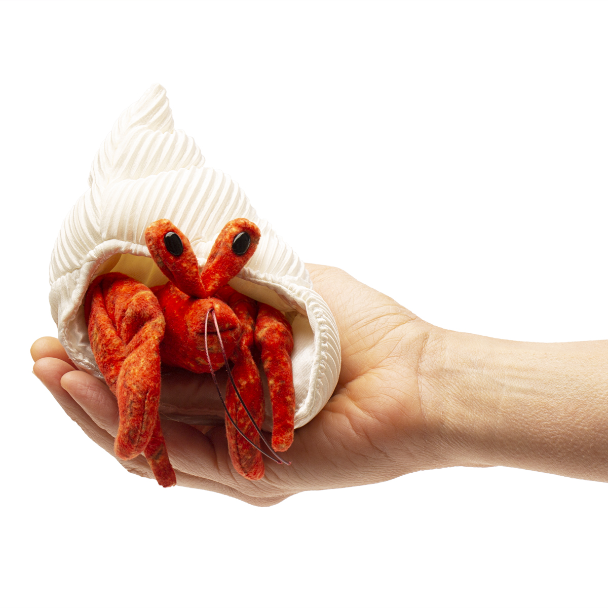 Folkmanis mini hermit crab finger puppet in orange-red with a white fabric shell, resting on a palm
