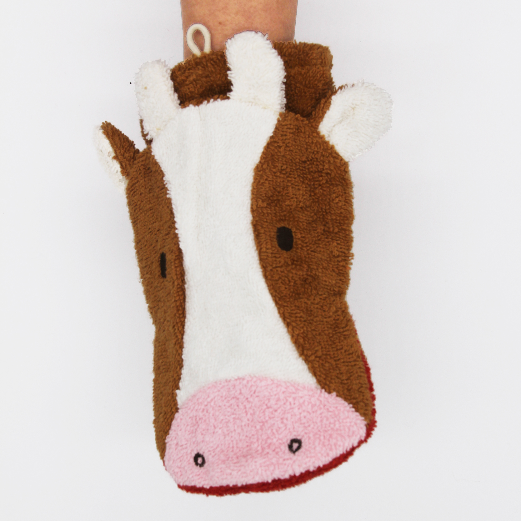 Fürnis organic washcloth cow Klara worn as mitt on arm, front view with brown patches and ears