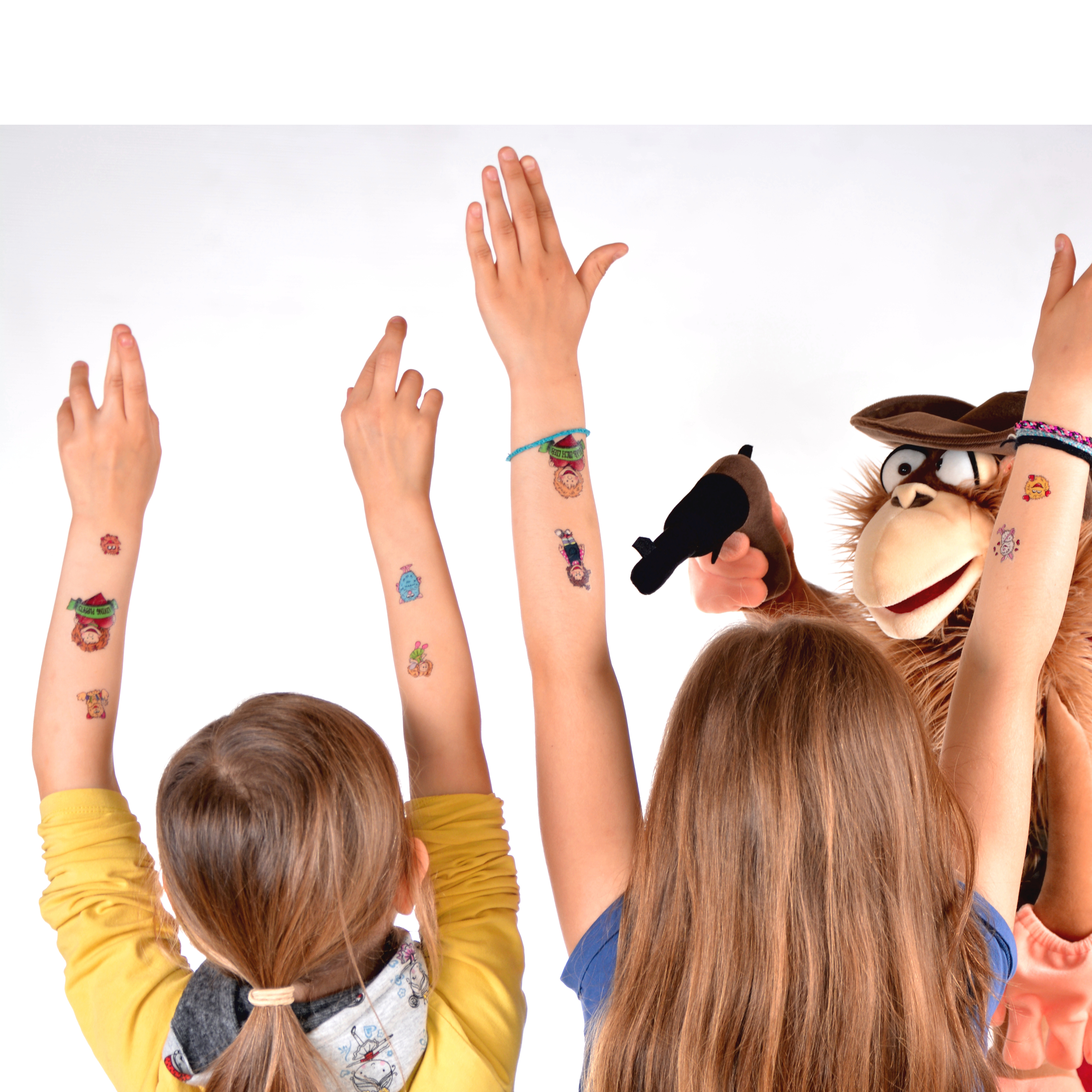 Children raising their arms with Living Puppets tattoos, a monkey hand puppet on the right, usage example