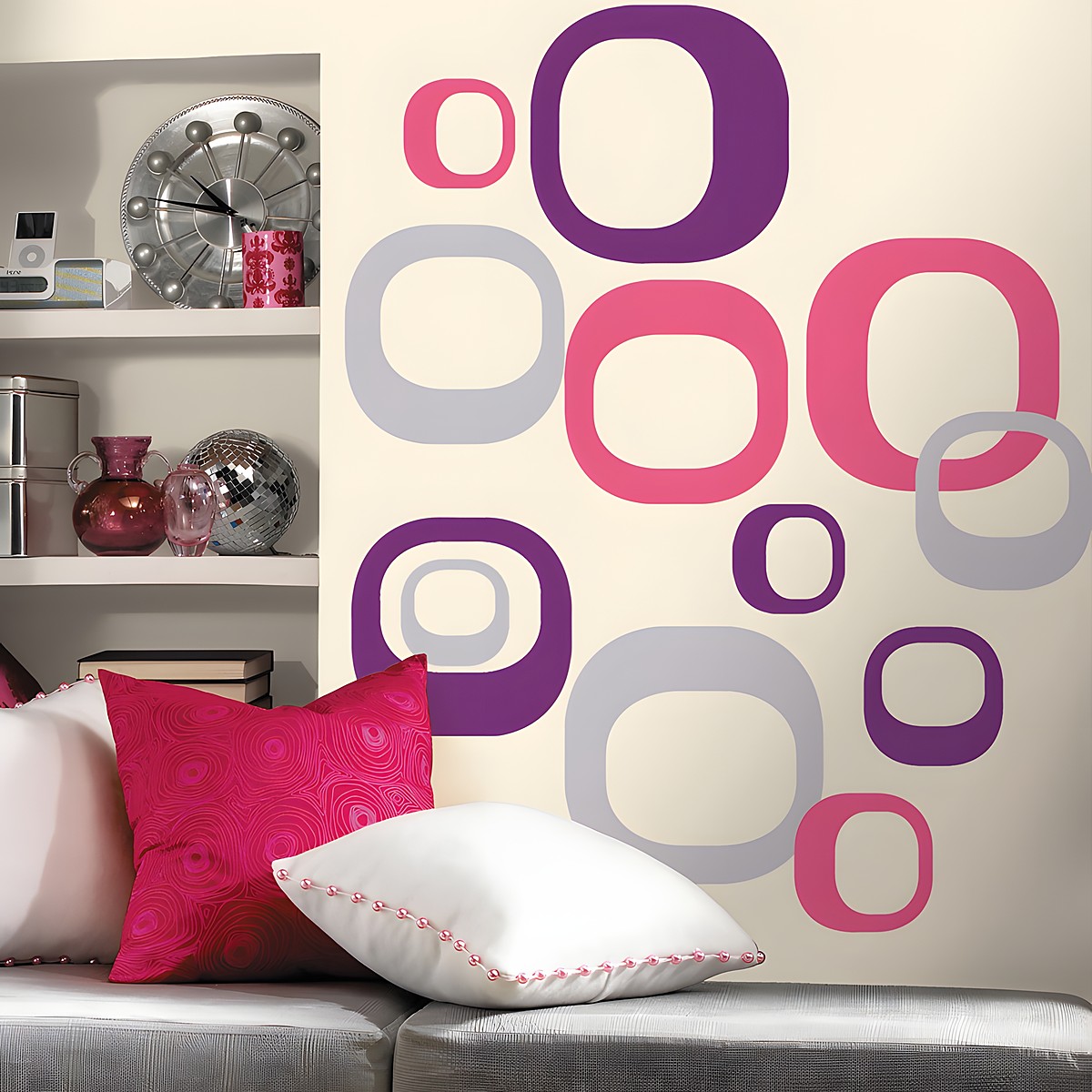 RoomMates wall decal Modern Ovals, pink, purple and grey oval rings on a cream-coloured wall next to a shelf