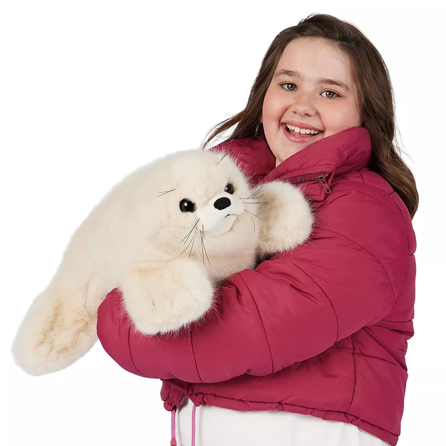 Mädchen in pinkfarbener Jacke hält die Folkmanis Handpuppe Robbenbaby mit weißem Plüschfell und schwarzen Knopfaugen im Arm.