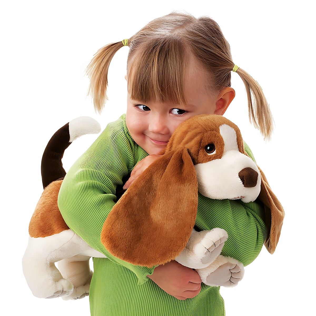 Kleines Mädchen hält die Folkmanis Handpuppe Basset mit langen Schlappohren und braun-weißem Fell im Arm.